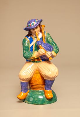 une figurine représentant un homme jouant d'un instrument de musique