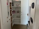 un petit dressing avec des armoires et des étagères blanches