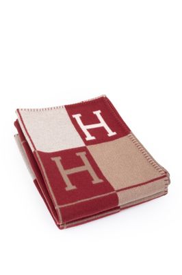 the blanket is red and beige with a monogram on it