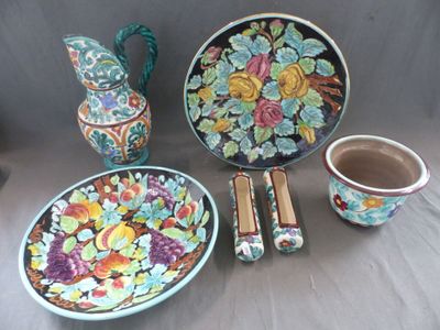une table sur laquelle se trouvent une assiette, un bol, un vase et d'autres objets