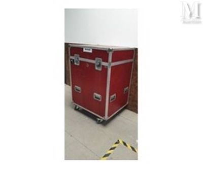 une image montrant une valise rouge posée sur un parquet en bois massif