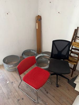 plusieurs chaises et une table dans une pièce où se trouve une chaise dans un coin