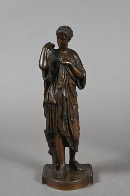 bronze statue of a woman holding a bird on a pedestal