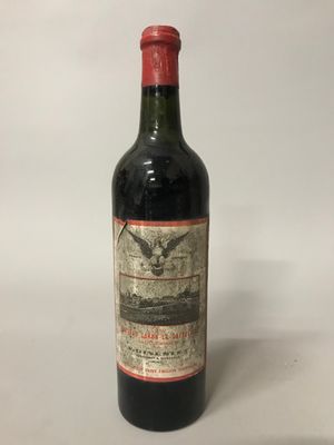 une bouteille de vin rouge posée sur une table blanche