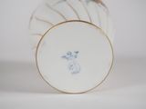 a white vase with a gold rim and a blue bird on it