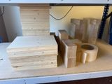 une pile de blocs de bois posée sur une étagère, à côté d'un rouleau de ruban adhésif