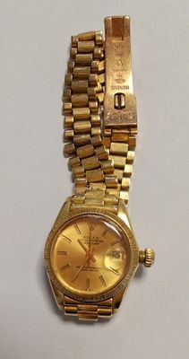 l'image d'une montre en or sur une surface blanche