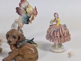 three figurines of dogs and a bird on a table