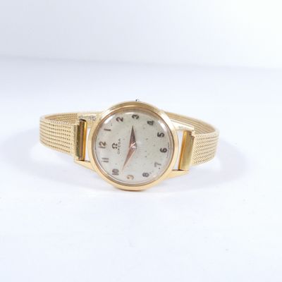 une image d'une montre-bracelet en or sur une surface blanche