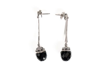 une paire de boucles d'oreilles ornées de pierres noires sur fond blanc