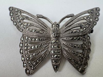 a close up of a butterfly brooch with lots of crystals on it