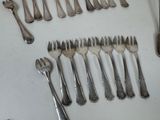many forks and spoons laid out on the table