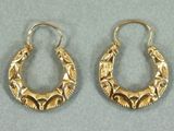 une paire de boucles d'oreilles dorées ornées d'un motif raffiné