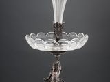 a silver plate with a glass vase on top of it