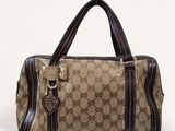 a brown and black handbag sitting on top of a white surface