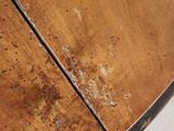a close up of a wooden table with peeling paint on it