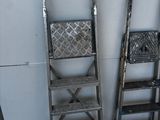 two ladders next to each other near a wall