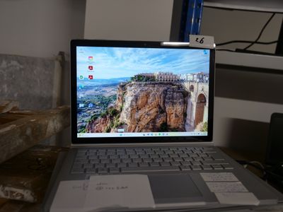 a laptop computer sitting on a desk with a mountain view on the screen