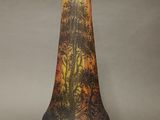 a glass vase with a painting on it on a table