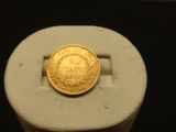 une pièce d'or posée sur un objet blanc