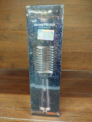 une brosse à cheveux dans une boîte transparente posée sur une table en bois