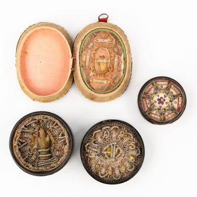 four small boxes with decorative designs on them sitting on a white surface