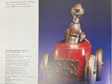a book with a picture of a man driving a toy car