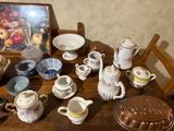 a wooden table topped with many different types of tea and coffee cups