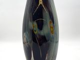 un vase noir orné d'un motif sur fond blanc