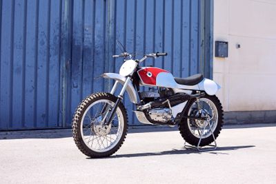 a white and red motorcycle parked in front of a blue building