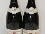 deux bouteilles de vin rouge posées sur une table blanche
