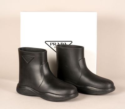 une paire de bottes de pluie noires avec le logo Prada sur le côté