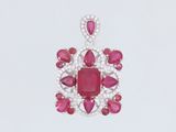 un gros plan d'un pendentif en rubis et diamants sur fond blanc