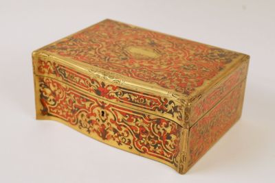 a gold and red box sitting on a white surface