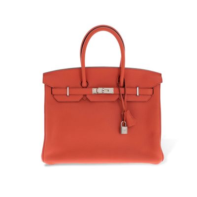 un sac Hermès rouge muni d'un cadenas sur la poignée