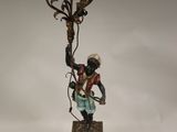 a figurine of a man holding a candelabra on a table