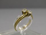 gros plan d'une bague en or ornée de trois diamants