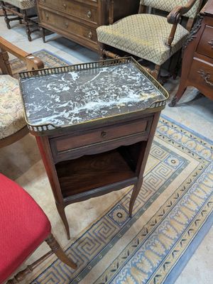 une petite table avec un plateau en marbre dans une pièce