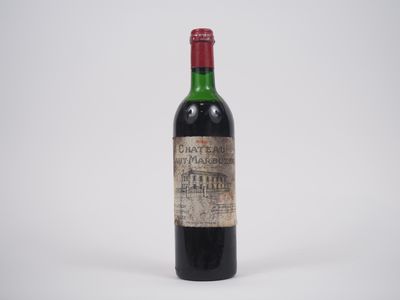 une vieille bouteille de vin posée sur une surface blanche