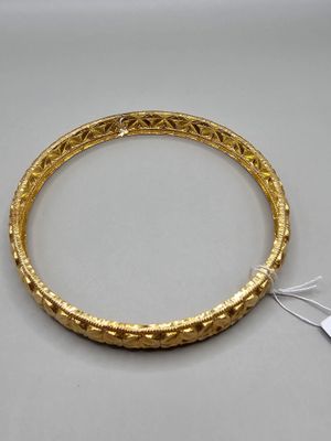 a close up of a gold bracelet with a tag on it
