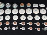 many plates and cups and spoons on the table