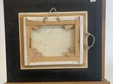 an old picture frame on a wooden easel with a rope around it