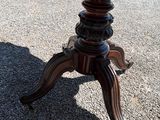 a wooden table with a wooden top on a gravel ground