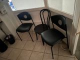 three black chairs in the corner of a room