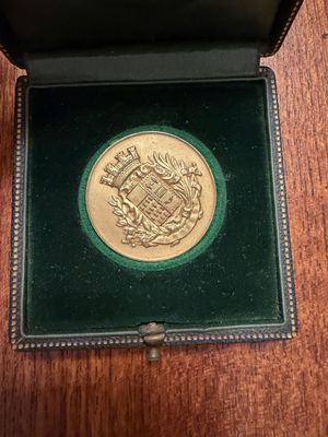 a gold coin in a green box on a table