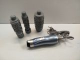 three different types of hair brushes and a blow dryer on a table