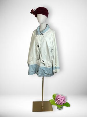 mannequin wearing a white jacket and a red hat with a flower in front of a white background