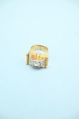 a gold and diamond ring sitting on a white surface
