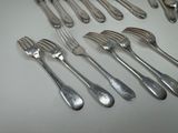 a lot of forks and spoons that are on the table