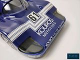 a close up of a blue race car on a white surface